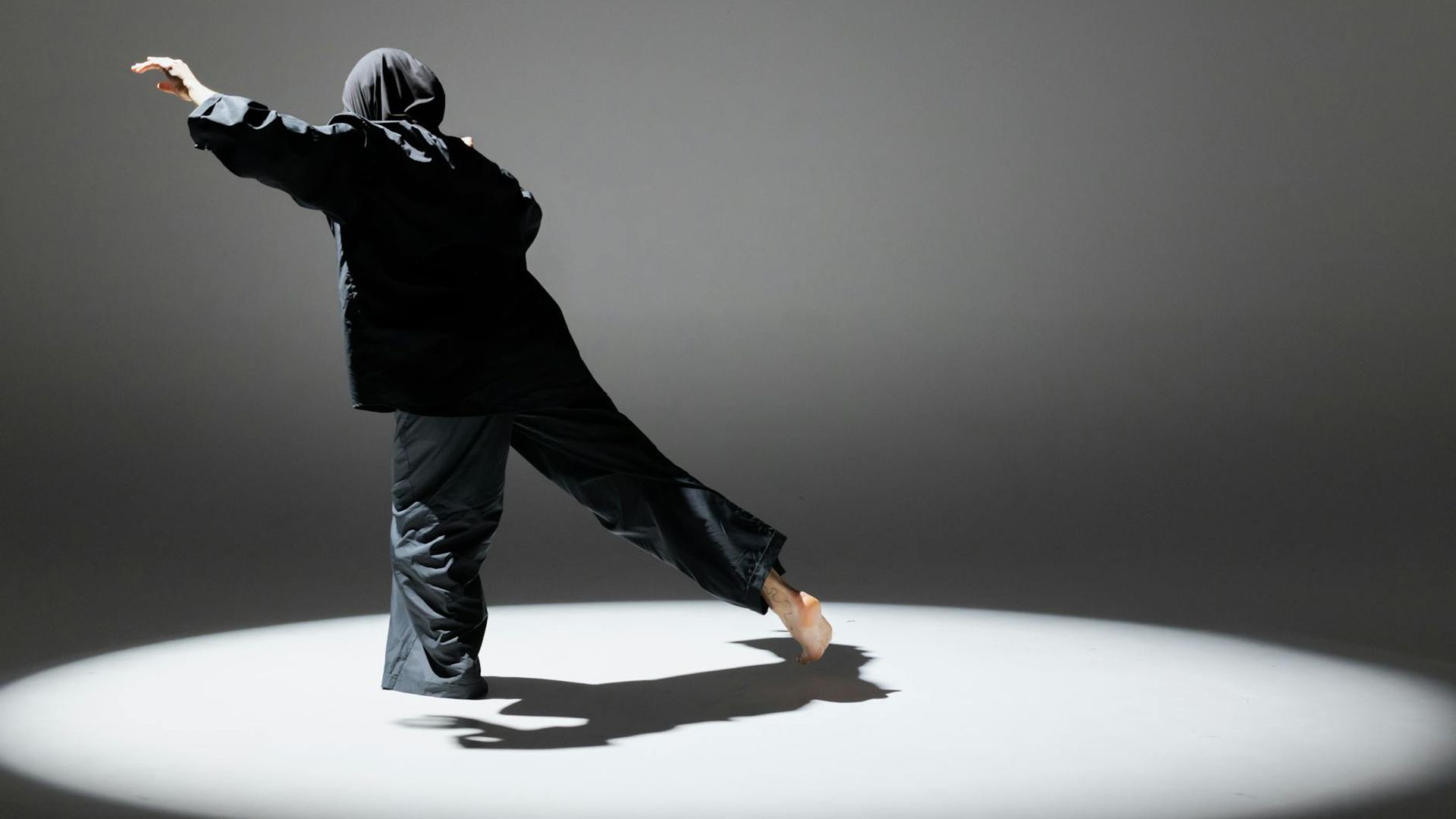 Active person doing dynamic movements in a dark modern studio space