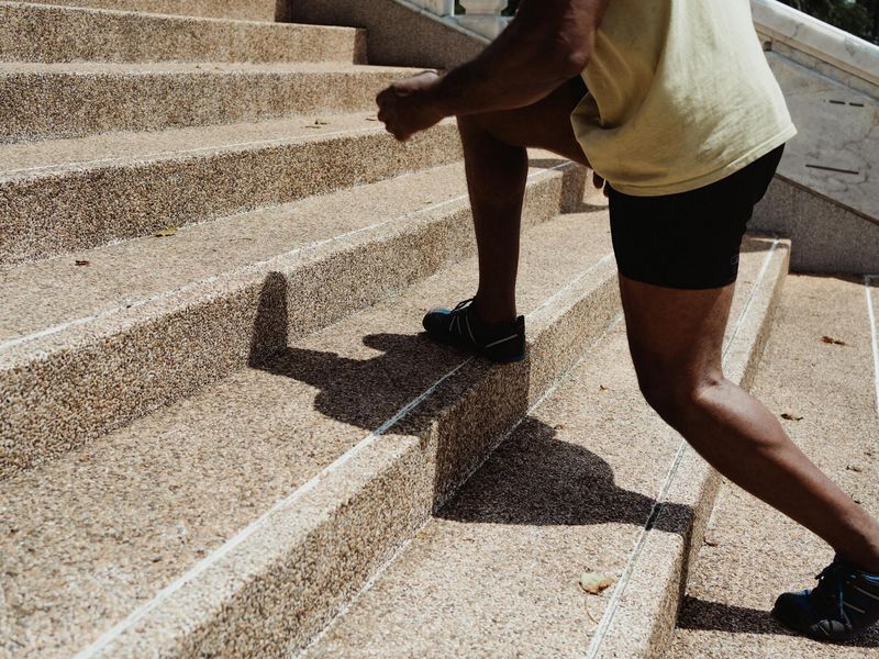 Person doing dynamic cardio steps in a minimal dark studio